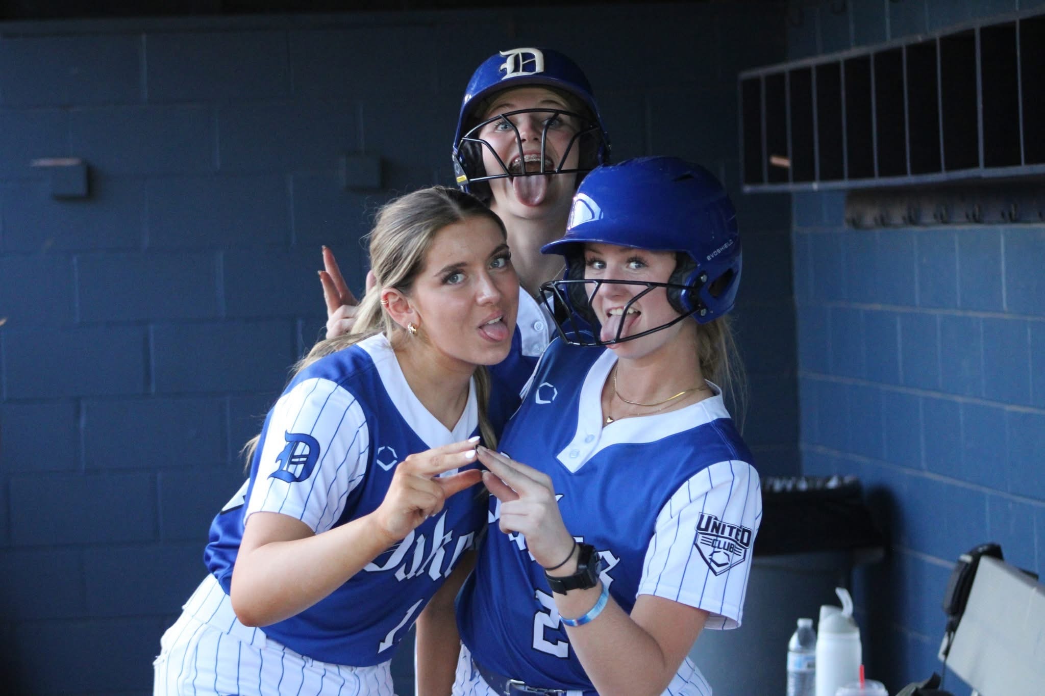 Lady Dukes players goofing around in the dugout