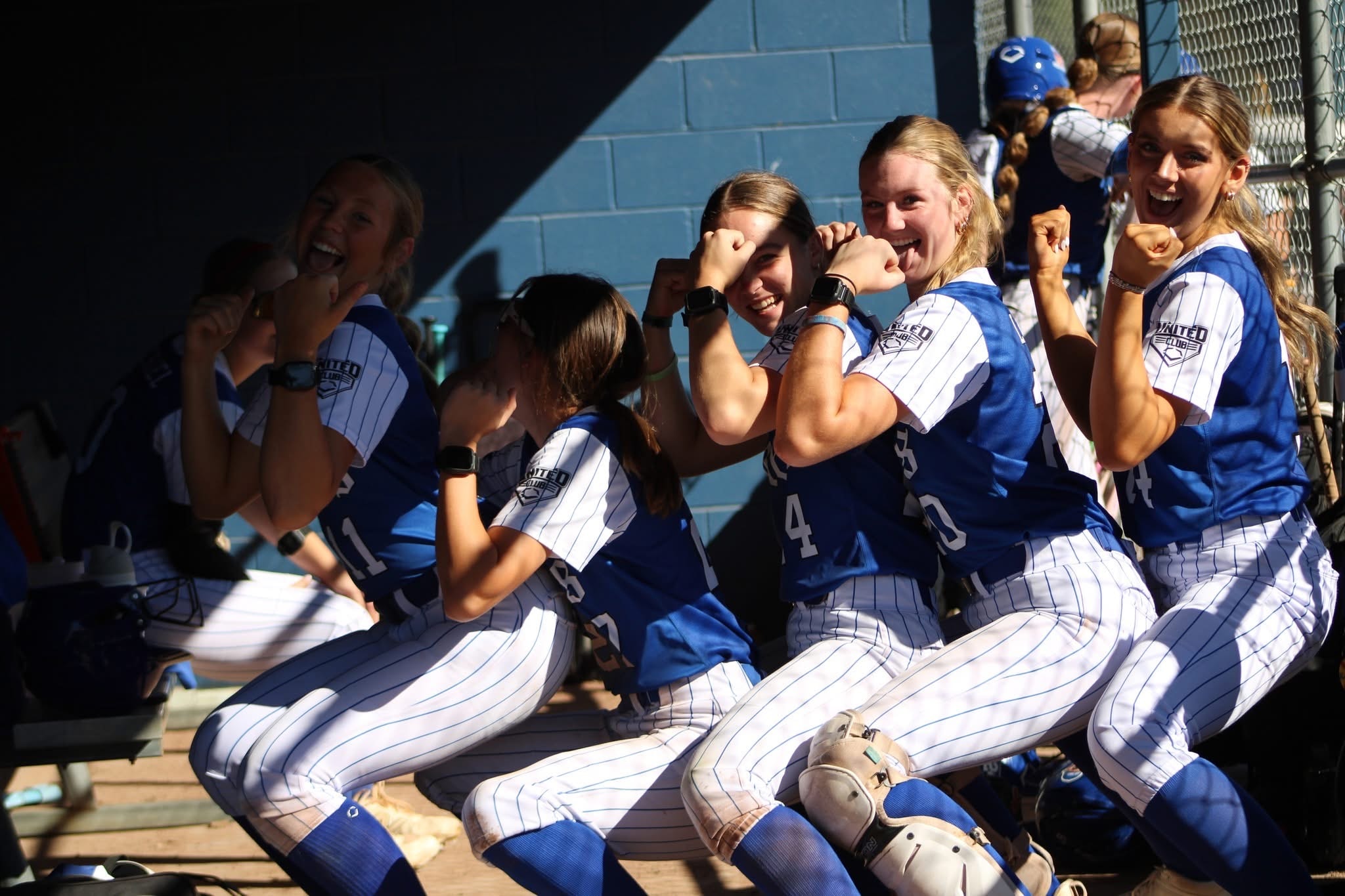 Lady Dukes players celebrating in the dugout