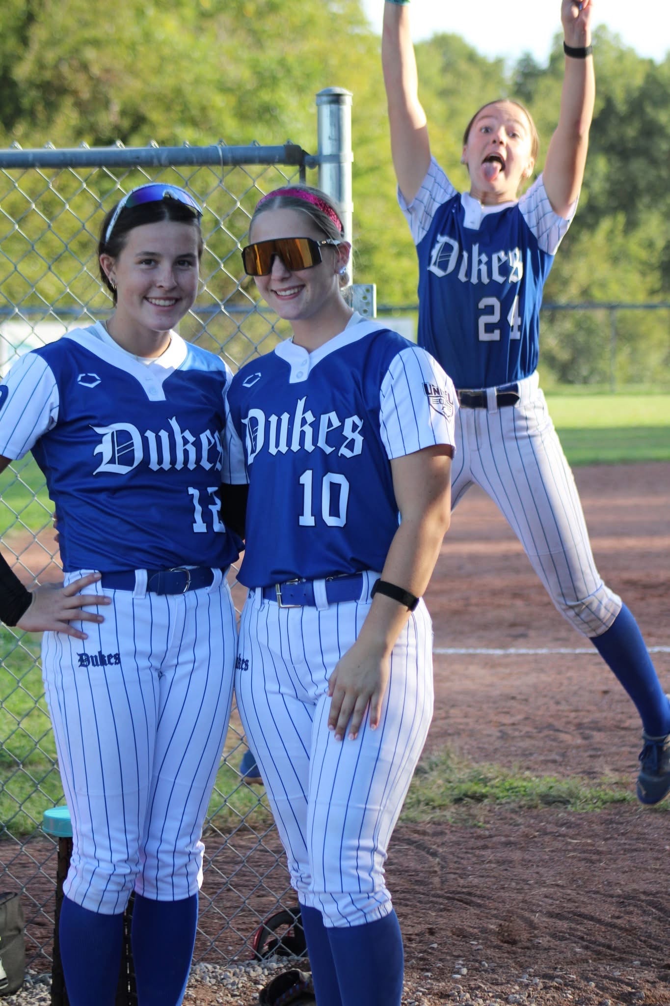 Lady Dukes players celebrating in the dugout